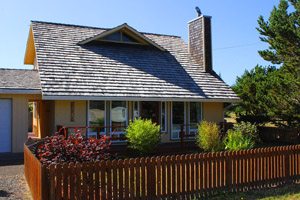 small yellow house with fenced-in yard